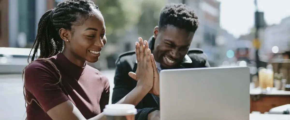 Two students working on laptop