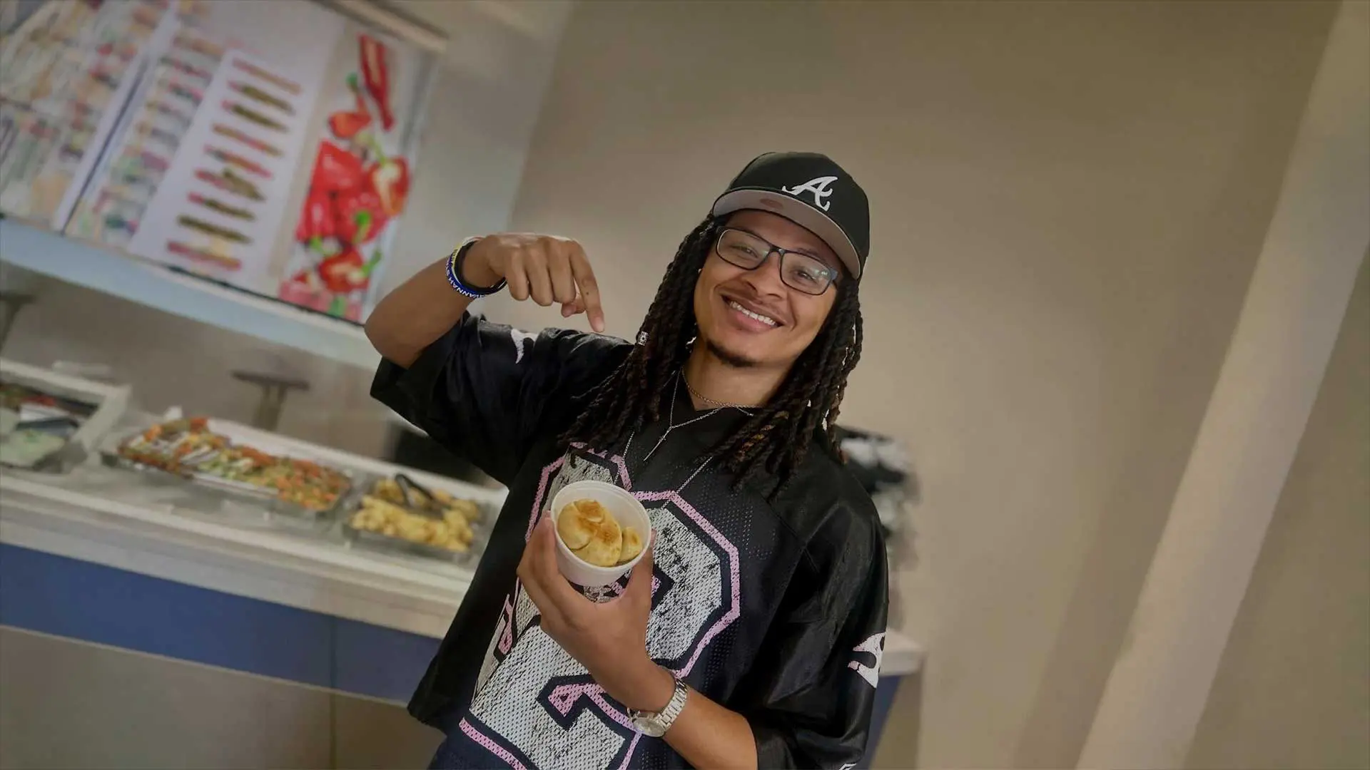 Student smiling while holding cup of garlic knots