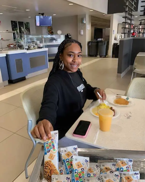 Student grabbing cereal bar from cart